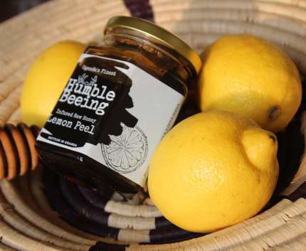 Humble Beeing lemon peel infused raw honey jar in a basket with fresh lemons